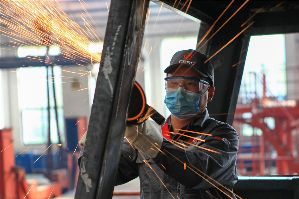 4月9日，来自湖北洪湖市的冷作钣金工高级技师顾欢正在精心打磨出口尼日利亚机车车体钢结构。史康 摄