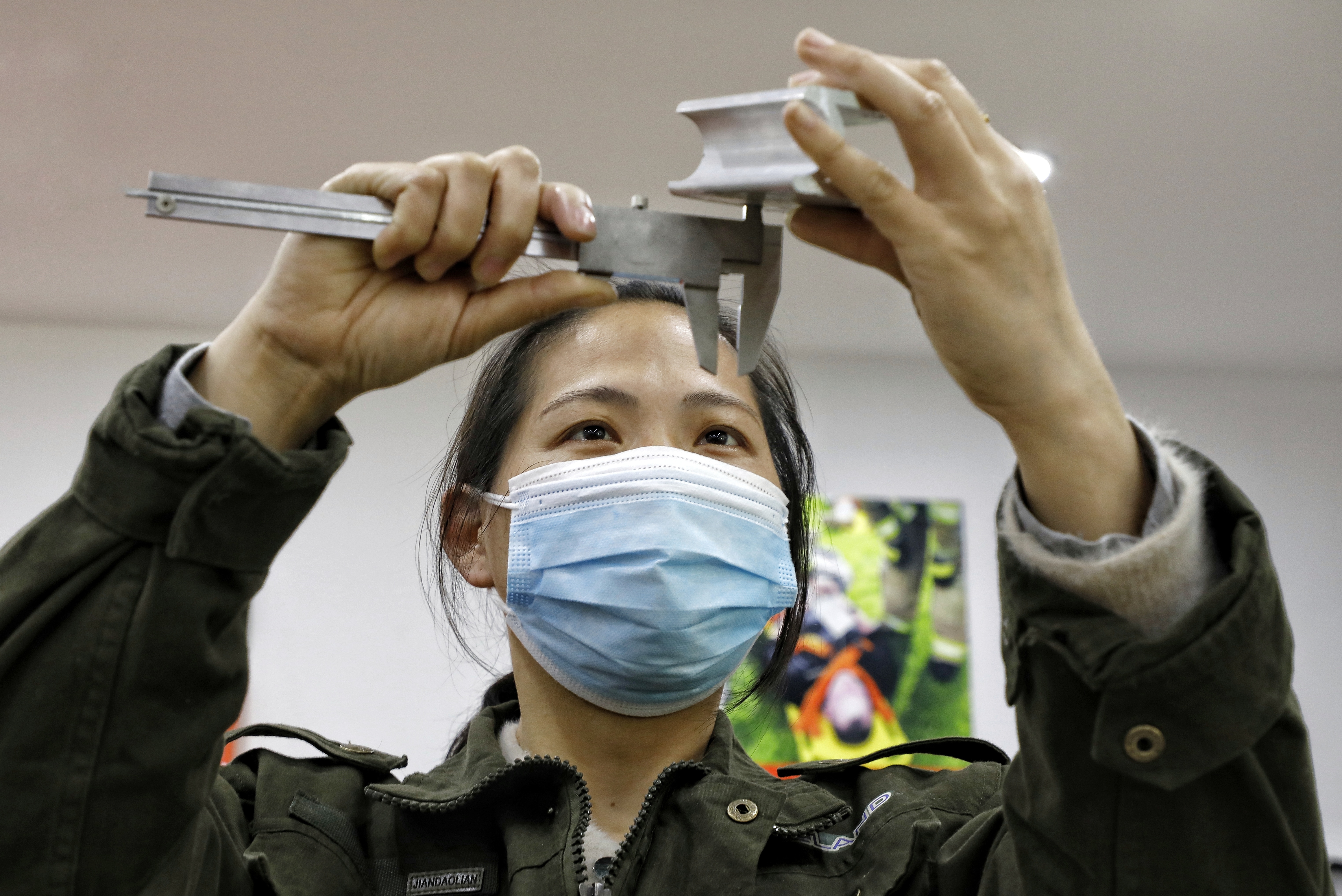 4月8日，在苏州张家港外贸企业担任质量检测员的湖北荆州市女工对出口医疗器械零部件认真检测。施柏荣 摄