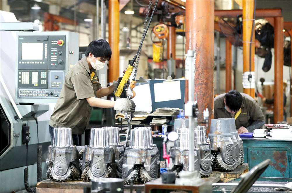 3月26日，来自湖北潜江市的丁凯(左)正在苏州一家公司车丝扣车间忙碌。华雪根 摄