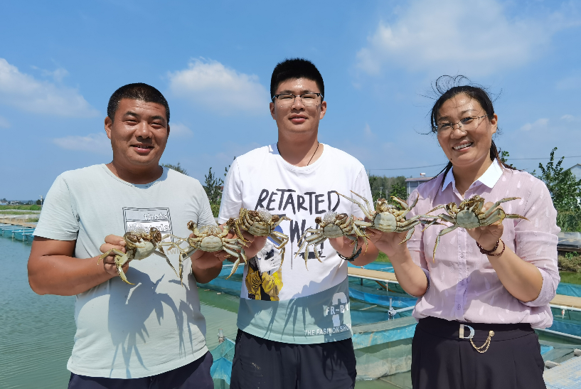胡晨曦（右）和家人一起展示半斤重的母蟹