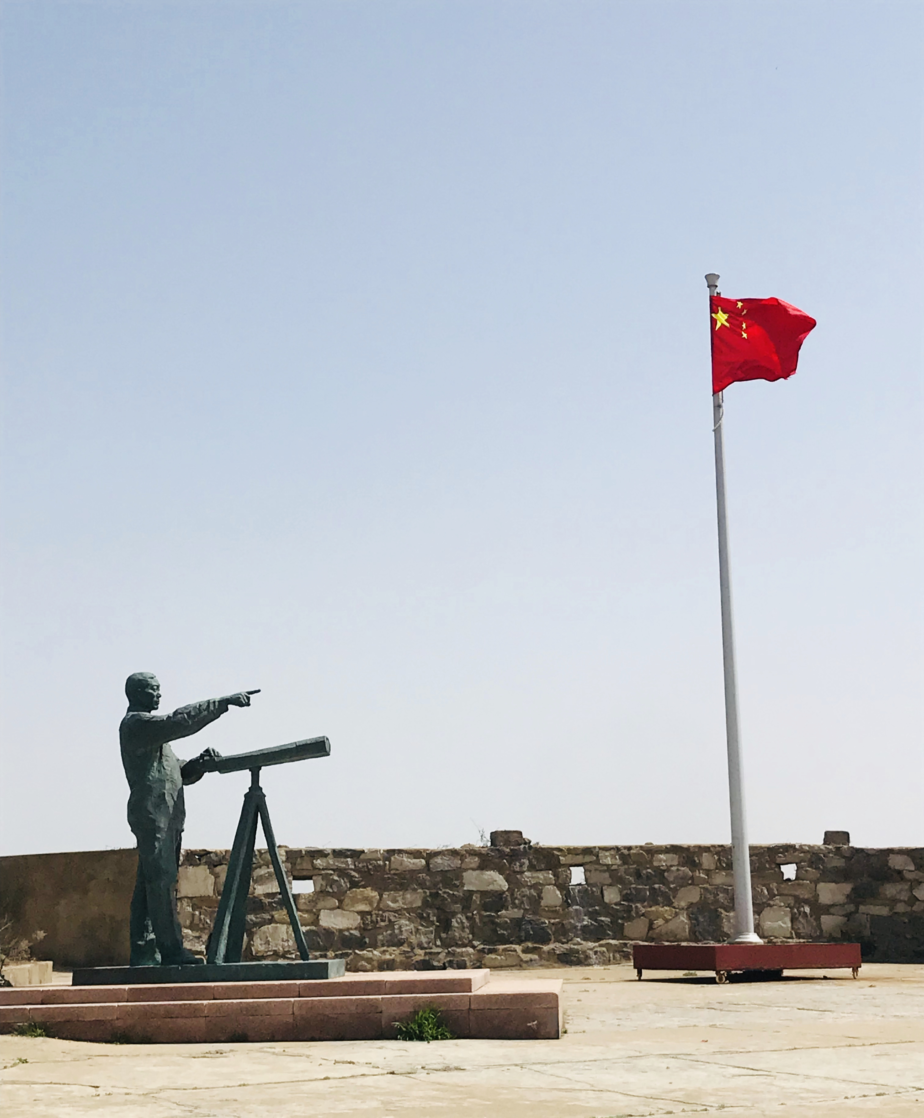 王继才铜像与国旗 夏兴俭 摄