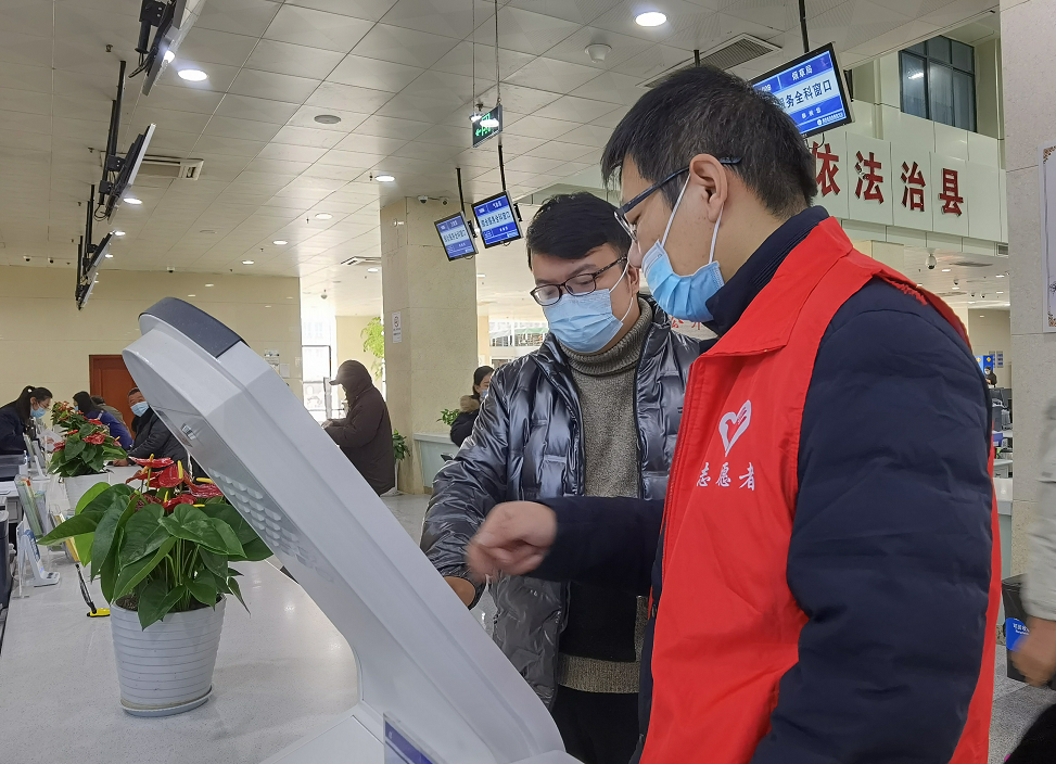 医保帮办志愿者正在帮助群众办理医保手续
