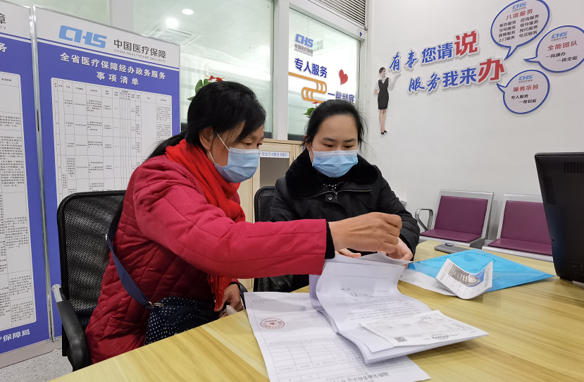 工作人员帮助江素兰办理医保手续