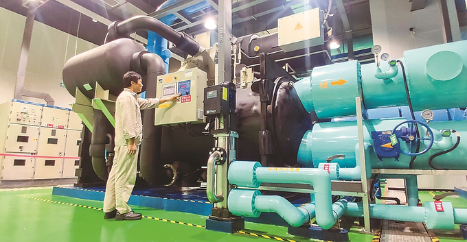 工作人员正在查看江水源热泵主机的运转情况。 本报记者 张筠 摄