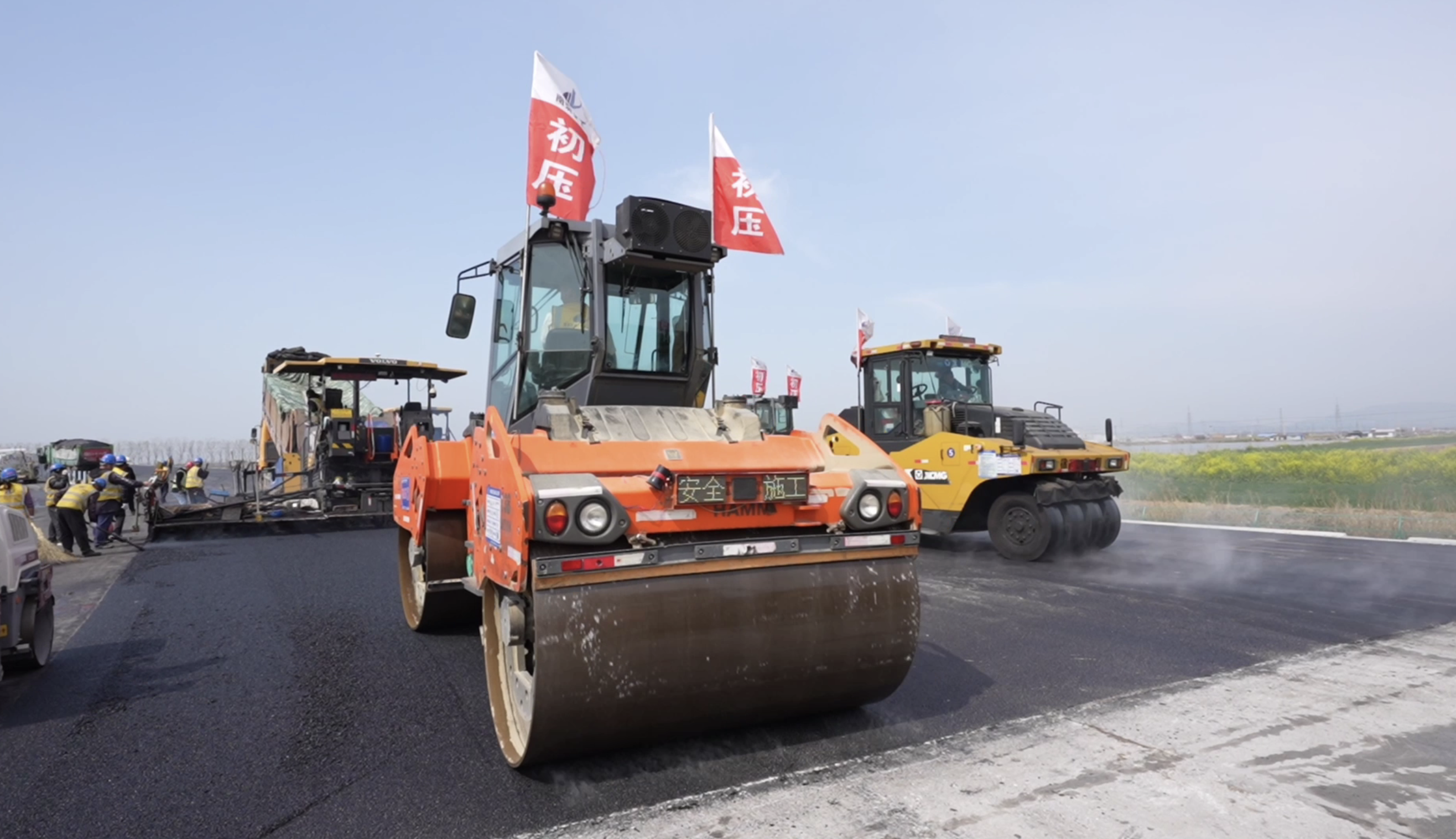 连宿高速公路21标段的沥青路面上,蒸腾起阵阵热浪,摊铺机轰鸣前行,压